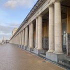 Classical building ruins with columns, staircases, and debris under hazy sky