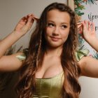 Woman with Long Wavy Green Hair and Dress in Soft Abstract Background