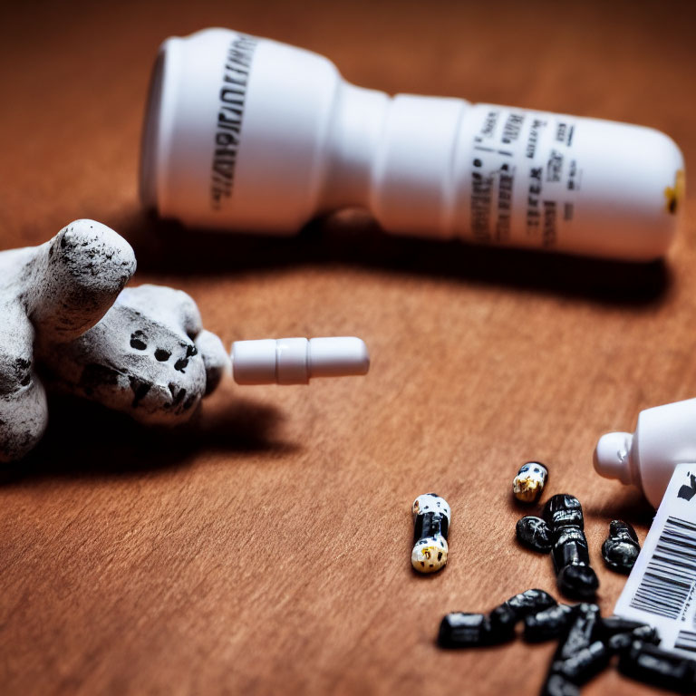 Toppled white pill bottle with scattered capsules and ceramic dog figurine on wooden surface