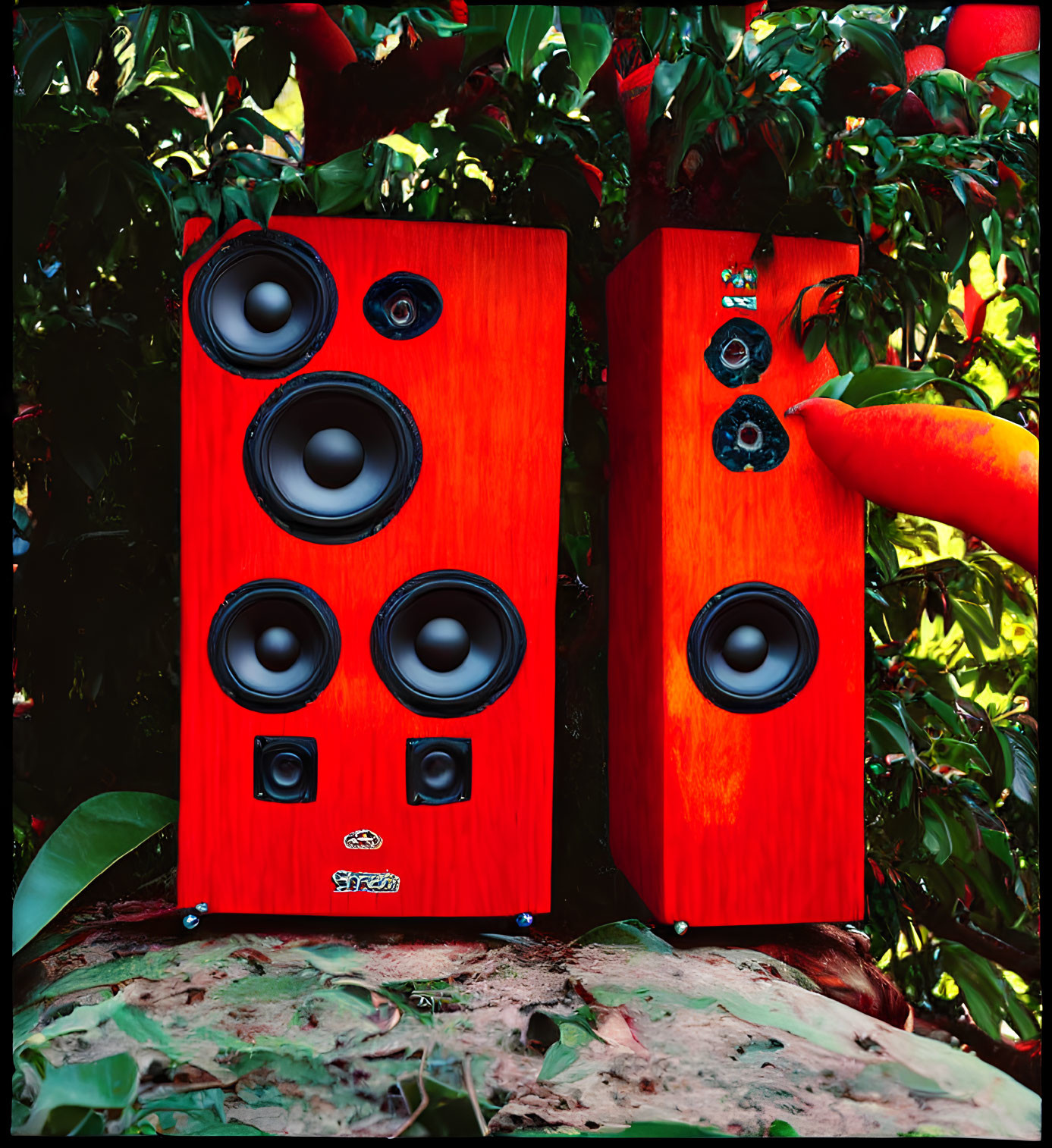 Red High-End Floor-Standing Speakers in Green Foliage