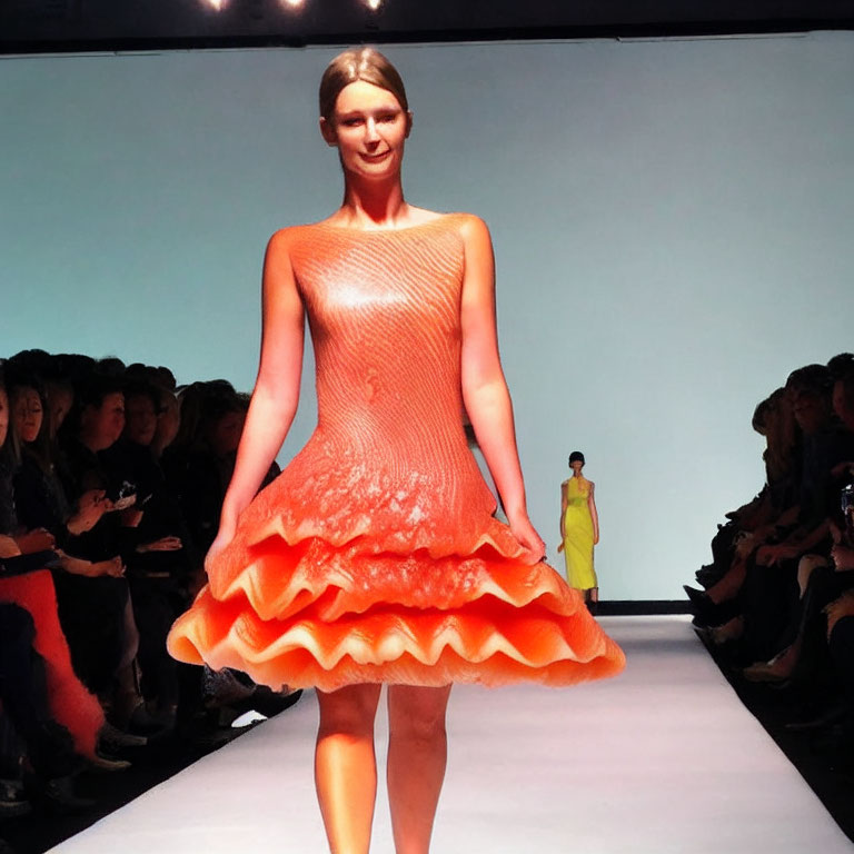 Fashion show: Model in orange textured dress with flared skirt