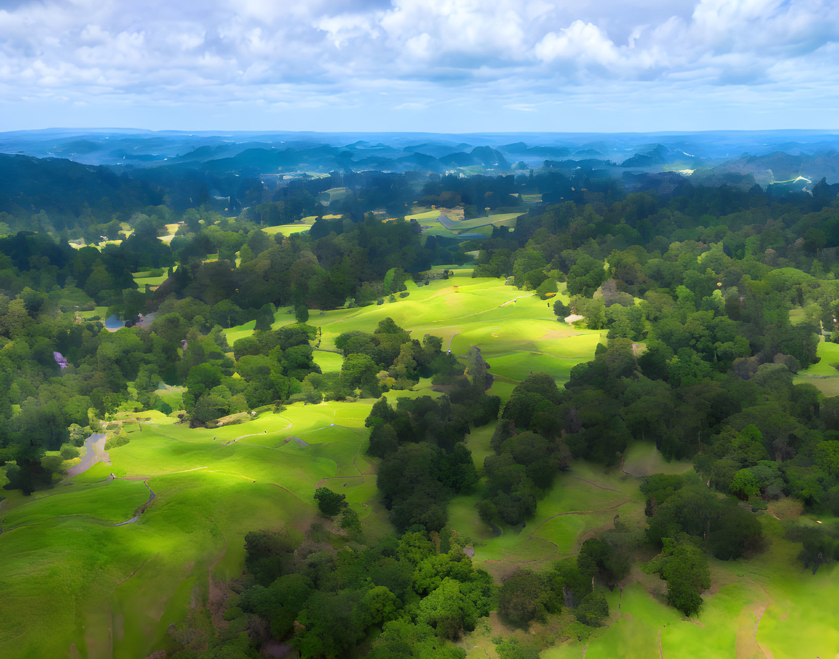 Scenic view of green landscape with rolling hills and trees under cloudy sky