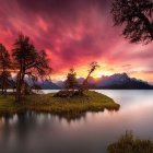 Tranquil sunset scene: pink clouds, silhouetted trees, mountain reflection