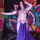 Fantasy portrait of woman with dark hair and jewel-encrusted headdress on purple background