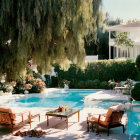 Elegant poolside scene with loungers, table, and greenery