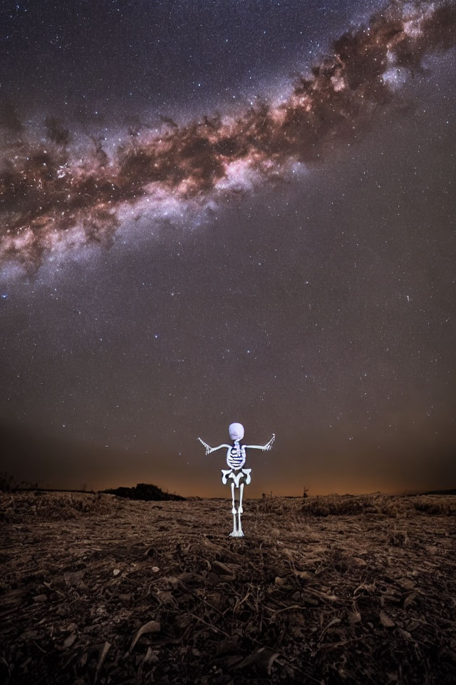 Skeleton under starry sky with Milky Way in barren landscape