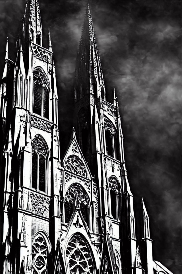 Gothic cathedral spires against cloudy sky in high-contrast black and white.