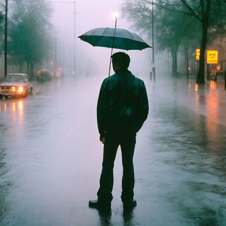 Person with umbrella in rain-soaked street with blurred cars and city lights