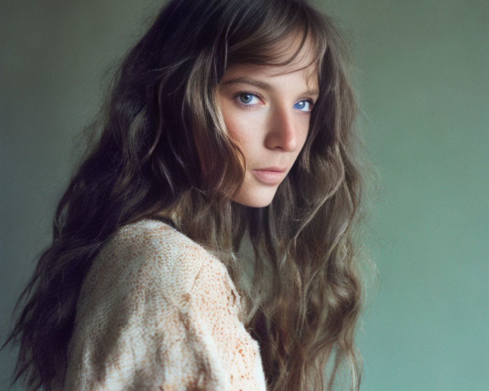 Person with Wavy Chestnut Hair in Beige Knit Sweater