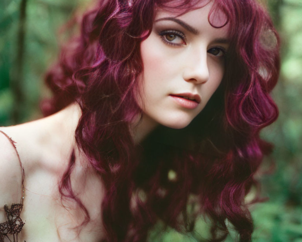 Purple-haired woman in green forest setting: striking contrast between hair and nature.