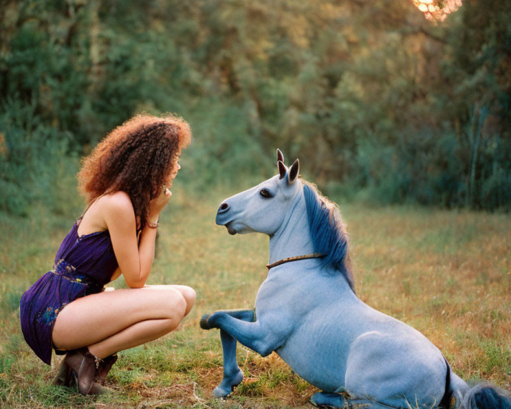 Purple-Dressed Woman Beside Blue Horse Sculpture in Sunset Field