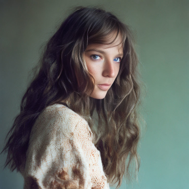 Person with Wavy Chestnut Hair in Beige Knit Sweater