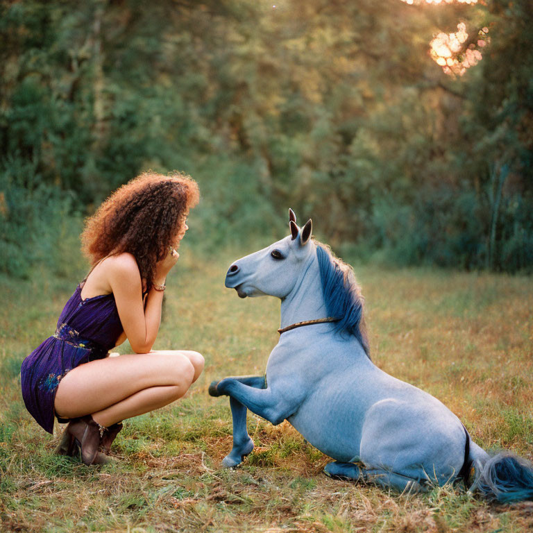 Purple-Dressed Woman Beside Blue Horse Sculpture in Sunset Field