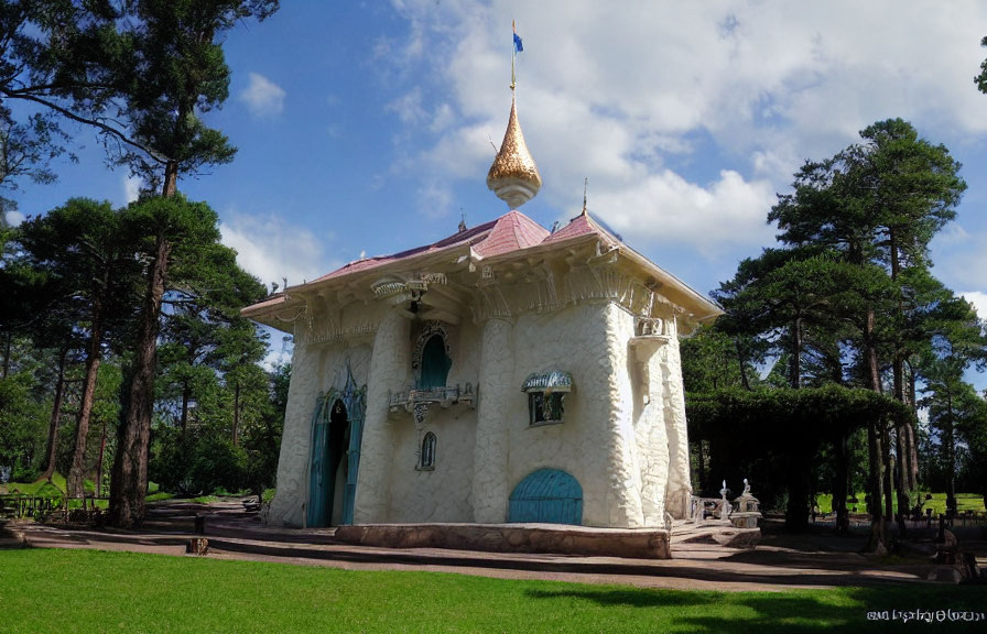 Fairytale-like building with golden spire in lush park with pine trees