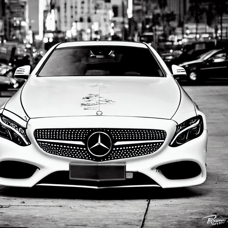 White Mercedes-Benz Car with Prominent Grille and Logo in City Setting