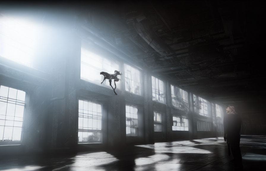 Dancer mid-leap in misty industrial hall with observer.