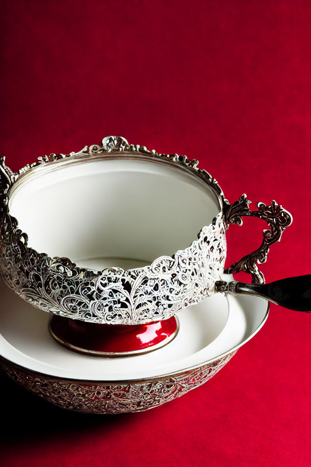 Silver Filigree Teacup and Saucer on Red Background