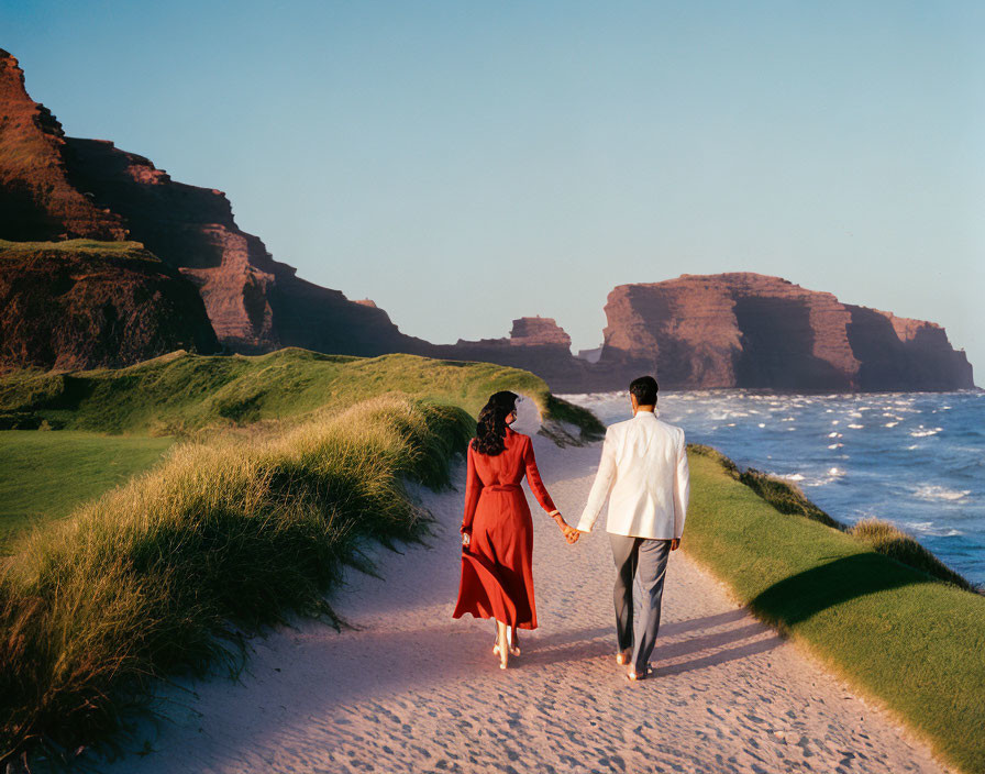 Couple walking on sandy beach path with ocean view