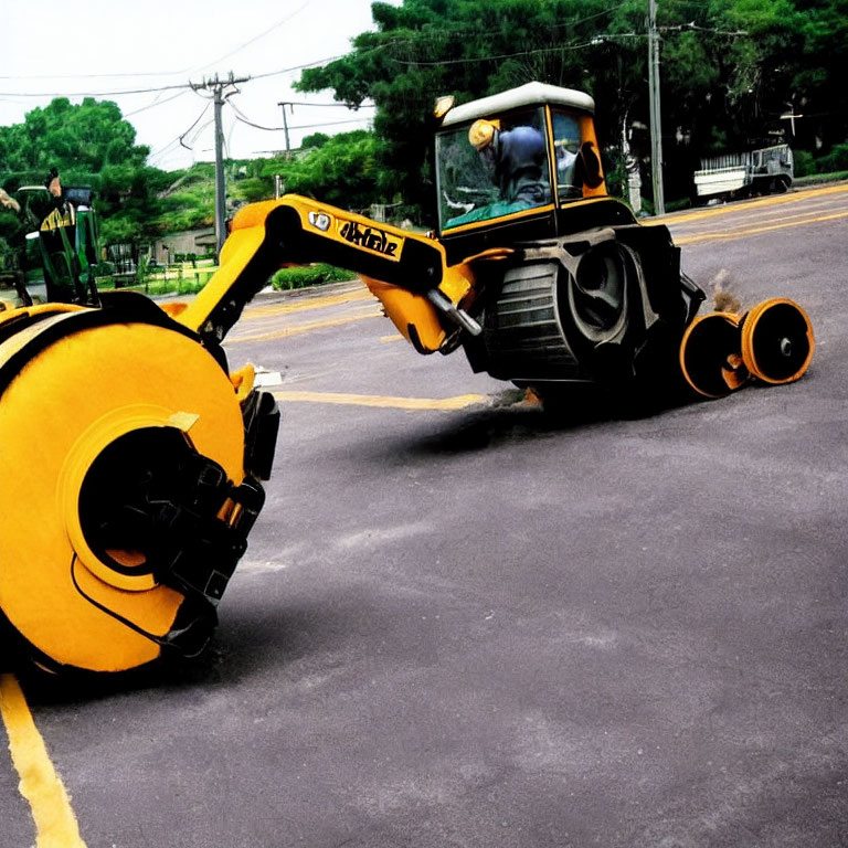 Yellow Road Milling Machine Removing Asphalt with Trees in Background