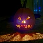 Glowing Jack-o'-lantern, bats, pumpkins, and spooky creature in a Halloween