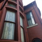 Surreal image of giant figure in flowing fabric by window