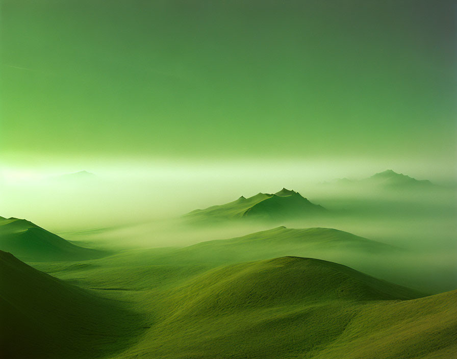 Green landscape with mist-covered hills and distant mountains.