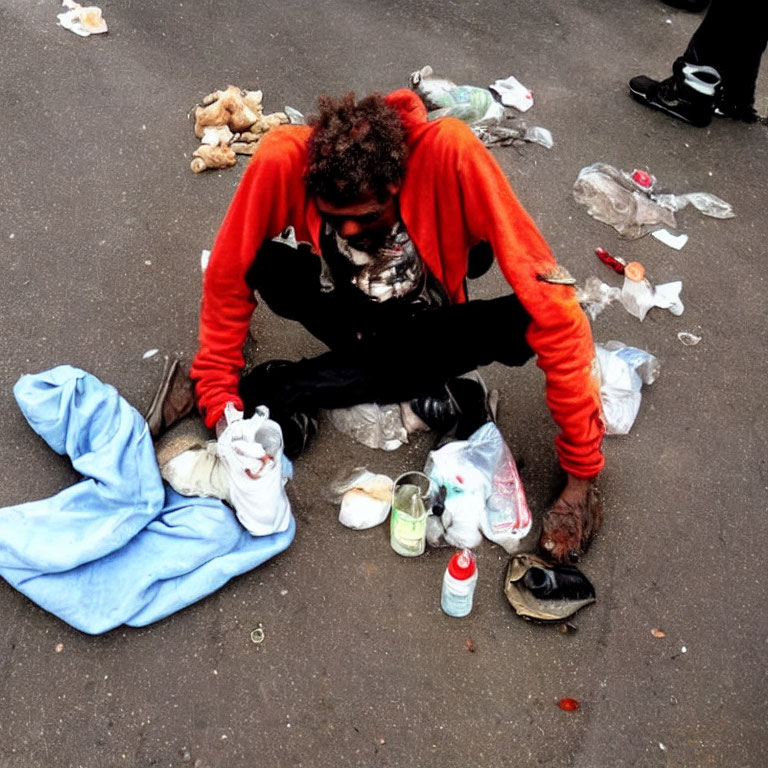 Disheveled person surrounded by litter and plastic bottles in red jacket