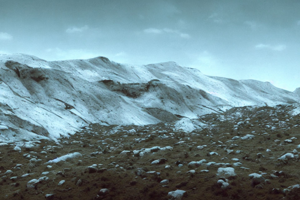 Sparse Vegetation on Rugged Hills Under Cloudy Sky