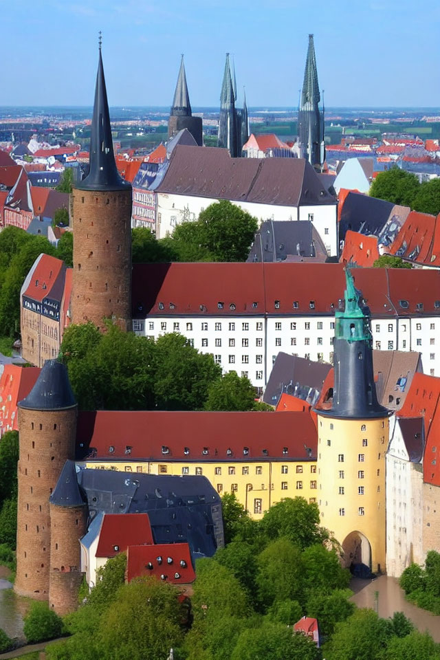 Historic cityscape with red-roofed buildings and church spires in aerial view