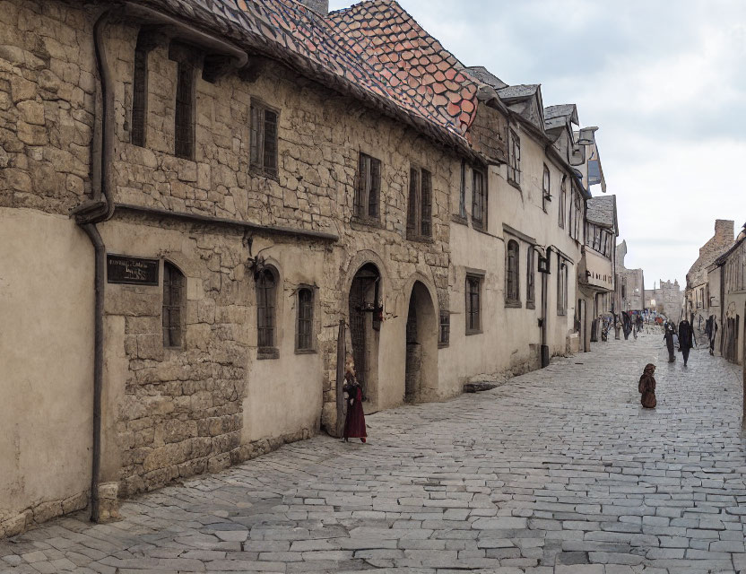 Historic town cobblestone street with old stone buildings and period costumes