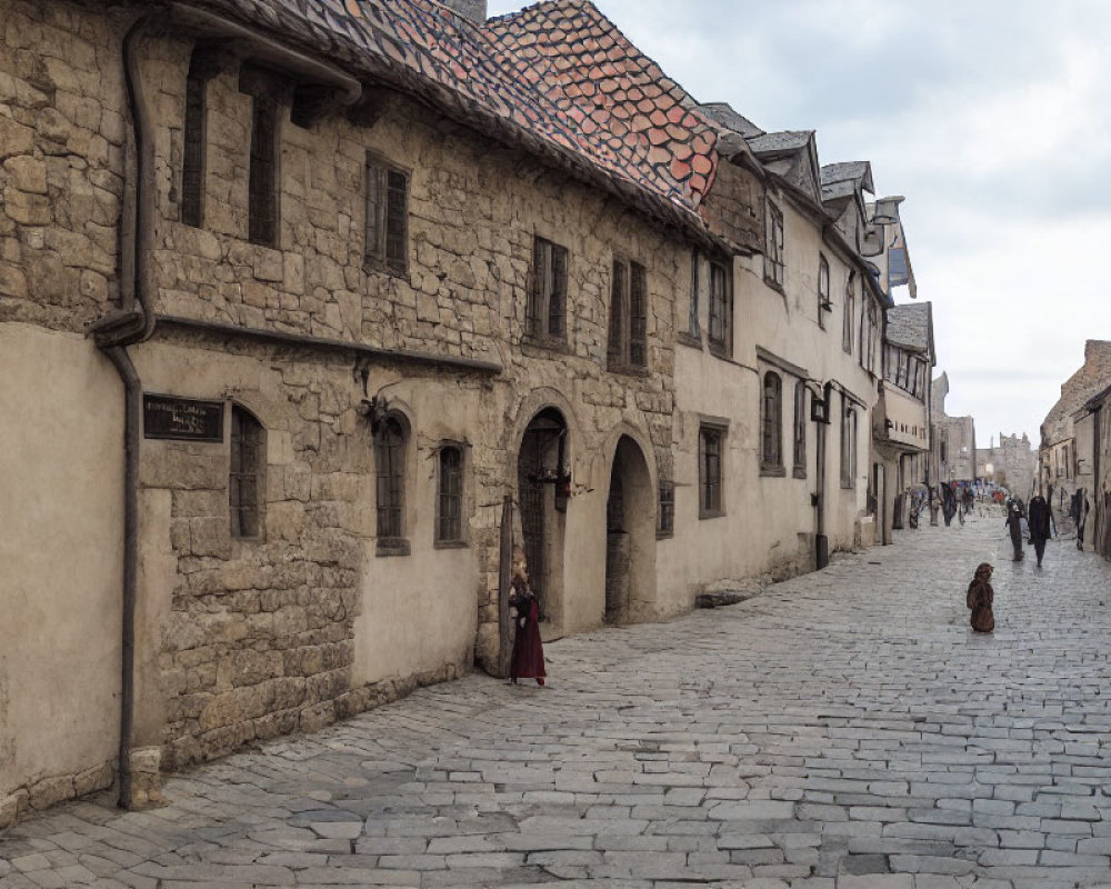 Historic town cobblestone street with old stone buildings and period costumes