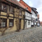 Historic town cobblestone street with old stone buildings and period costumes