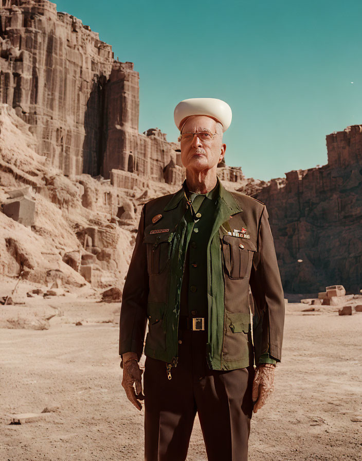 Elderly man in green military uniform with medals in desert canyon