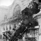 Monochrome photo: Steam locomotive crashed into station building