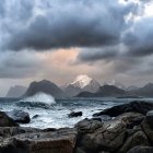 Decaying shipwreck on rocky shore with dramatic sky and crashing waves