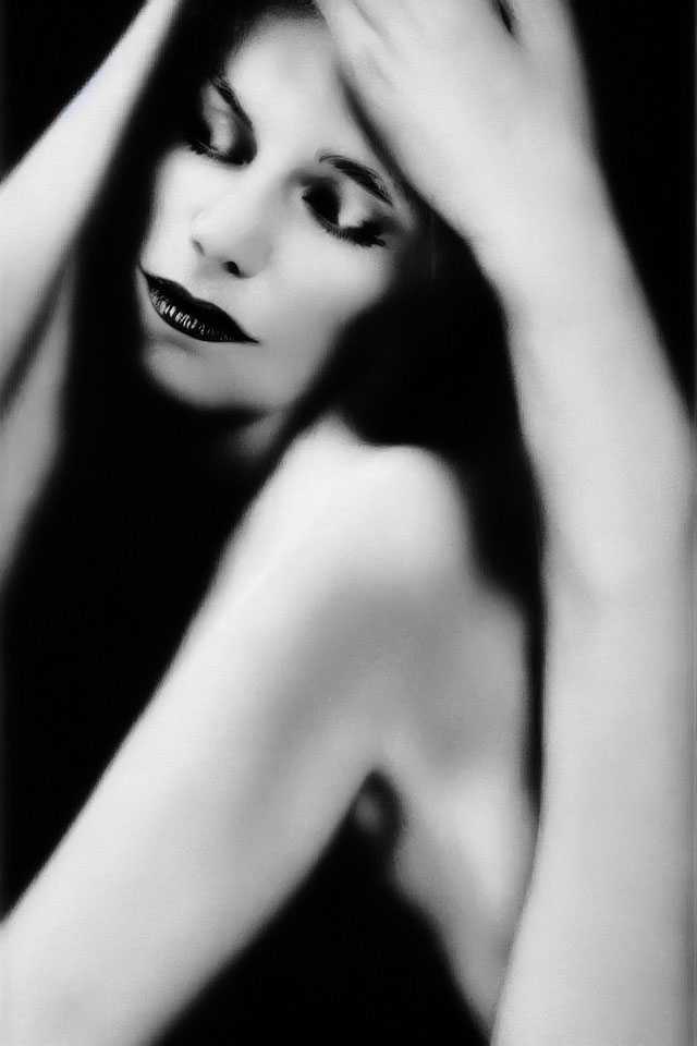 Monochrome portrait of woman with striking makeup and hand on head