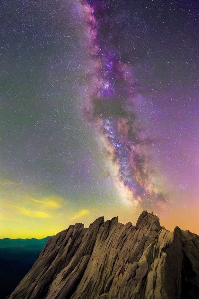 Starry night sky over rugged mountain peak