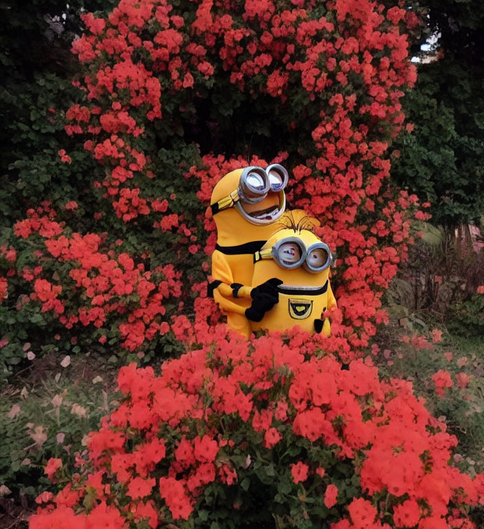 Two individuals in Minion costumes surrounded by red flowers.