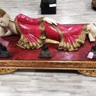 Reclining figure in golden crown on ornate platform