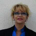 Blonde-haired mannequin head with digital eyewear, earrings, and necklace in black blazer