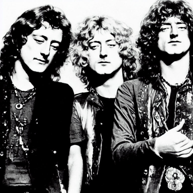 Black and white photo of three men with curly hair in patterned shirts