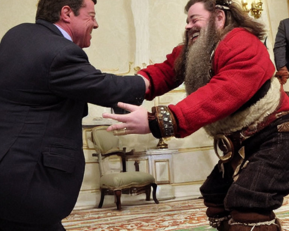 Men in formal and festive attire shaking hands and laughing