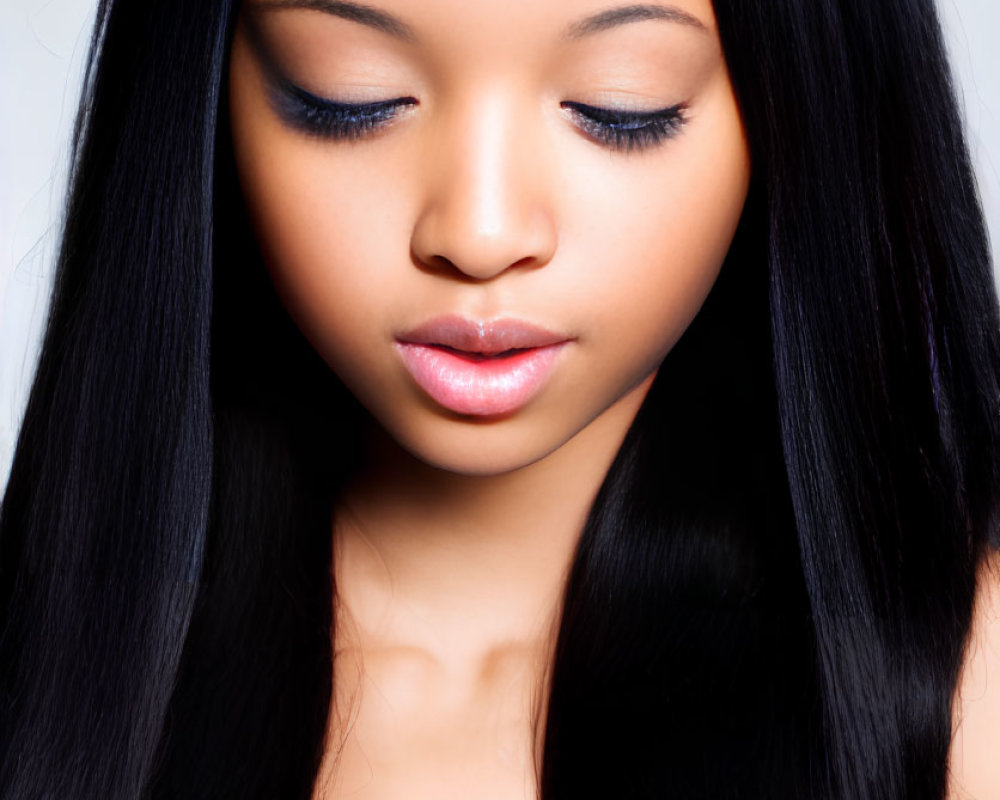 Portrait of young woman with long black hair and blue top