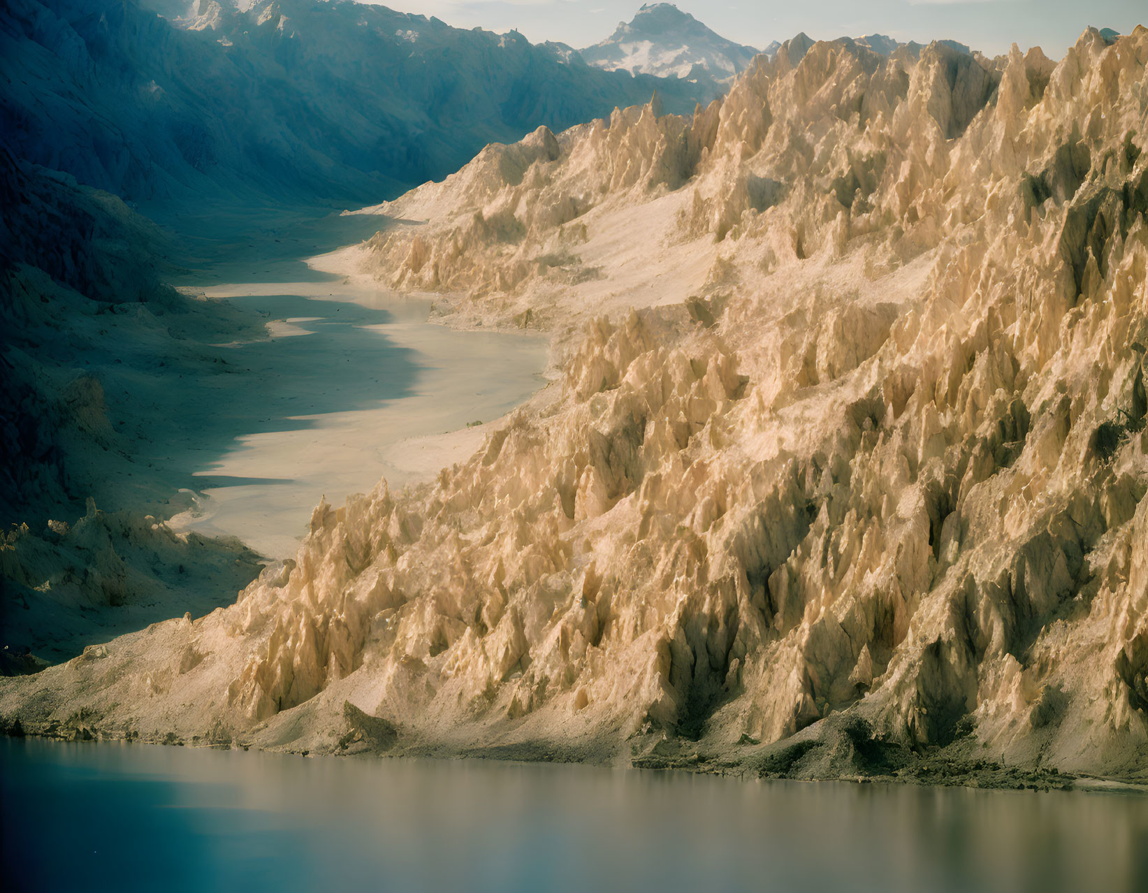 Tranquil mountain landscape with blue lake and sunlit peaks