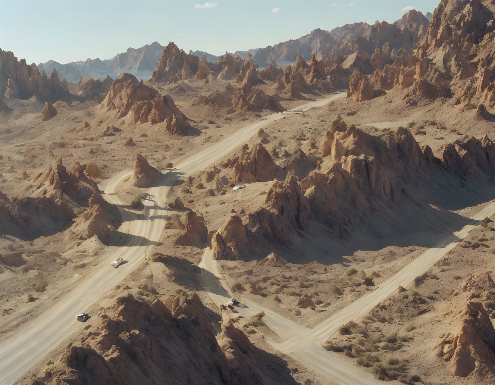 Desert road winding through rugged, rocky landscape with cars and towering peaks