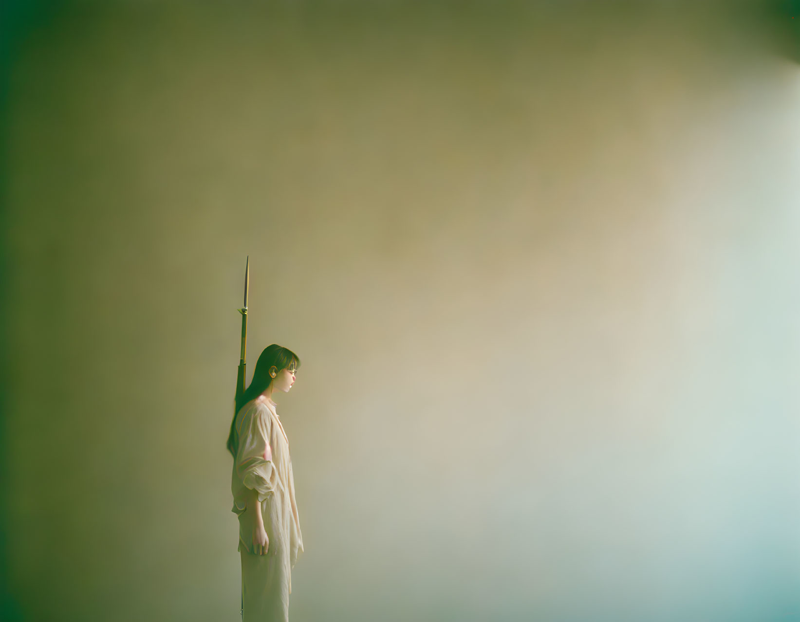 Person in White Shirt Holding Object Against Green Background