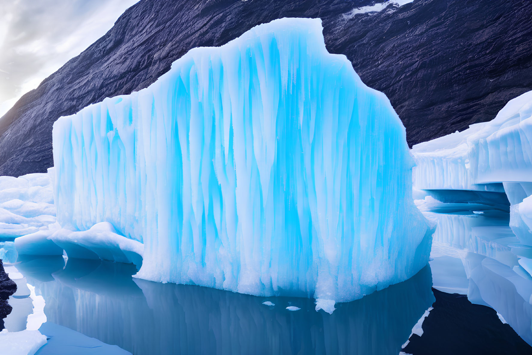 Majestic blue iceberg surrounded by ice formations in calm waters