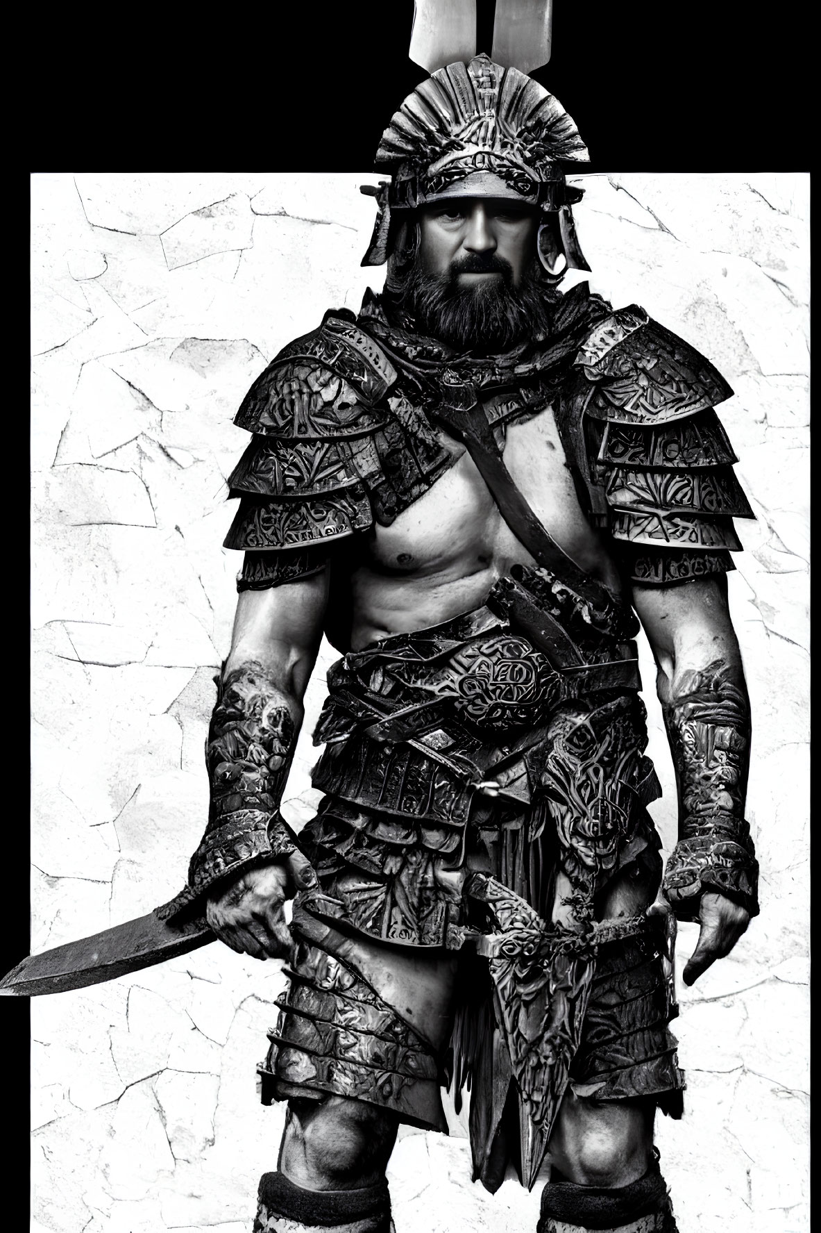 Monochrome image of person in ancient warrior costume with sword, helmet, and armor against cracked backdrop