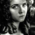 Monochrome portrait of woman with curly hair and floral accessory