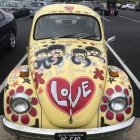 Customized Volkswagen Beetle with steampunk design and heart-shaped decal parked on city street